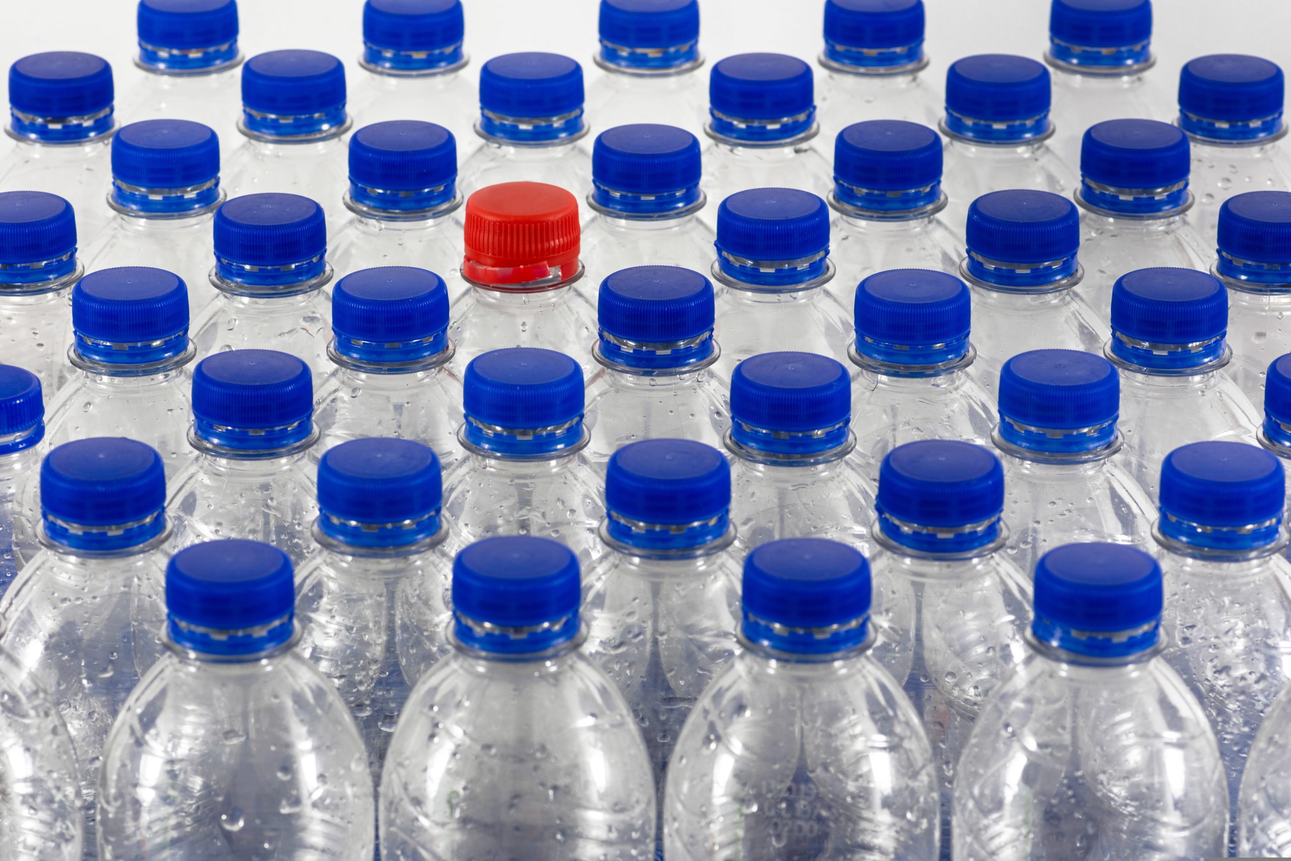 plastic bottles with blue lids and a single red lid