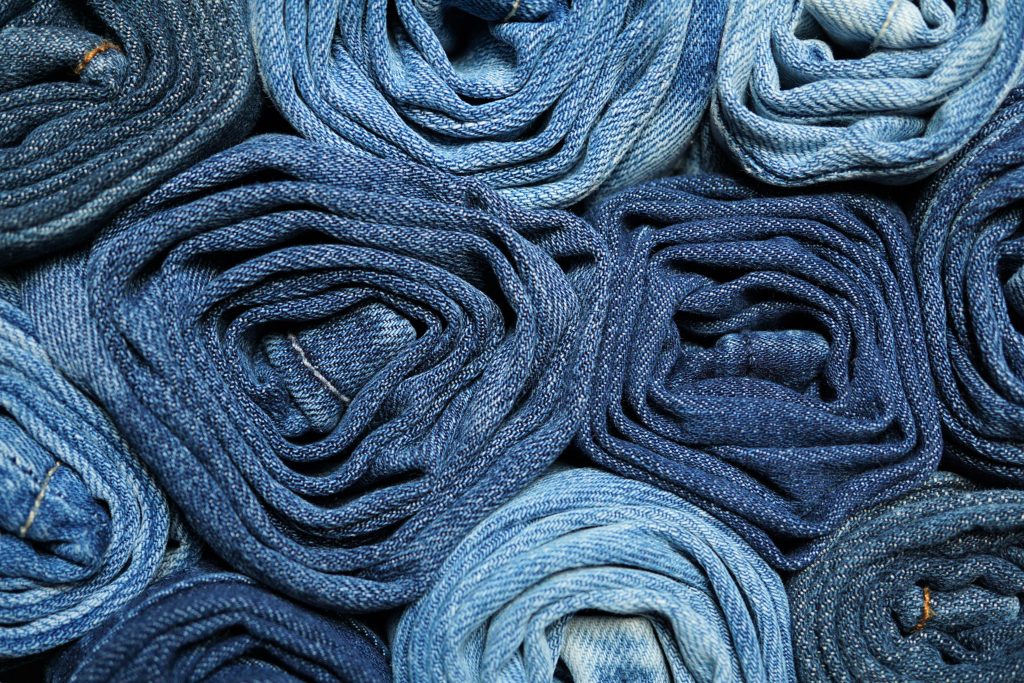 Several pairs of rolled up blue jeans 